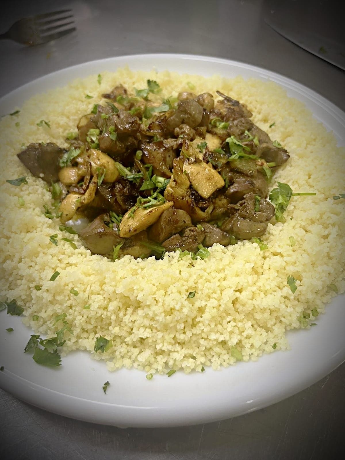 Couscous topped with savory sautéed chicken liver, mushrooms, and green herbs.